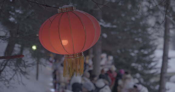 雪天户外挂着红灯笼人群聚集的景象