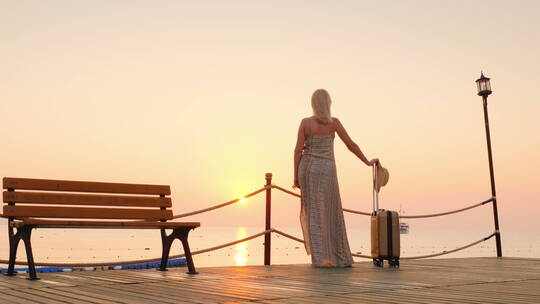 夕阳下女人站在码头上