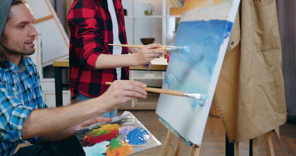男艺术家和可爱男孩在家庭工作室架上的未来照片上画蓝色大海