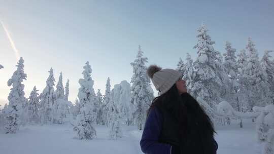 美丽的女孩在芬兰北极圈拉普兰的雪林中探索