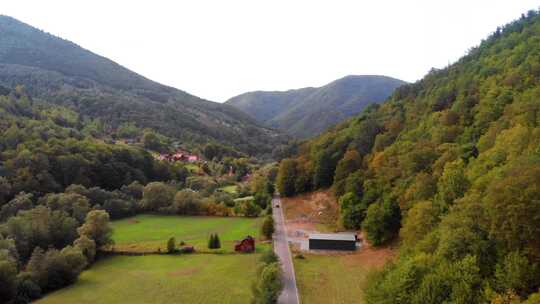 汽车在有村庄森林和山脉的直线道路上行驶