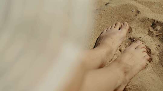女孩的脚享受沙滩上的白沙