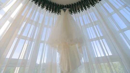 新娘奢华婚纱挂在全景玻璃上婚礼当天的早晨视频素材模板下载