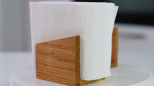 带纸质餐巾的木制餐巾架在厨房桌子空间上旋