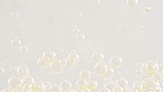 金色透明气泡形成并漂浮到白色背景透明表面