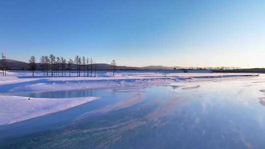 夕阳下内蒙古北方不冻河平静水面雪雾袅袅