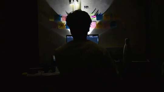 年轻人在电脑面前用电脑背影