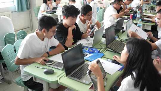 学生们在教室里使用电脑学习讨论的场景