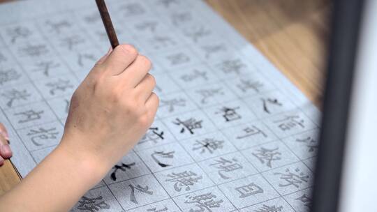 用字帖练习毛笔字的亚裔女性视频素材模板下载