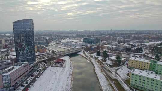 下雪的奥洛穆克市，河景，桥梁和带镜面窗户的高楼，寒冷的冬天视频素材模板下载