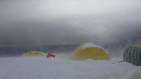 大风中的新疆慕士塔格峰雪山的登山者C1营地