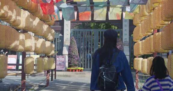行人穿行挂有灯笼的通道