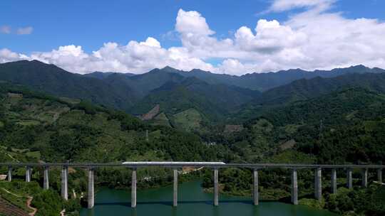 航拍山谷隧道中驶出的高铁列车