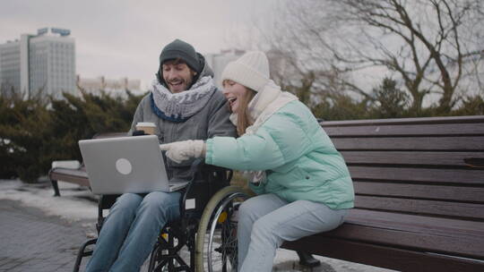 残疾人和朋友在笔记本电脑上看视频