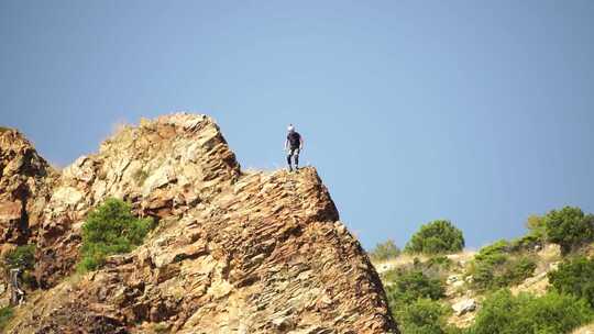 男性基地跳伞运动员跳下火山岩边缘，打开降