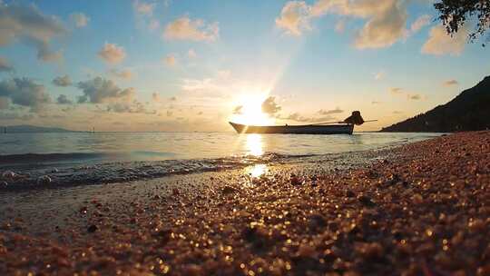 海边夕阳下的小船与沙滩