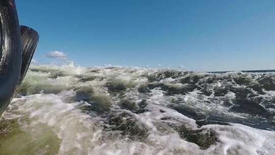 船只旁波涛汹涌的水面近景