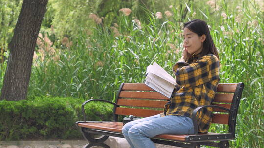 中国女性美女在公园树林看书学习