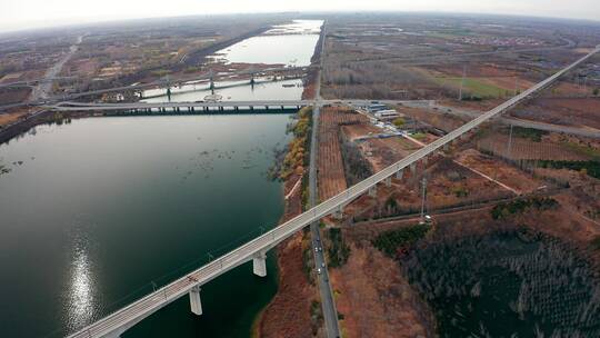 4K航拍晴朗深秋跨越河流的铁路公路桥