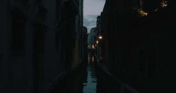 人们走在有河的黑暗小巷里