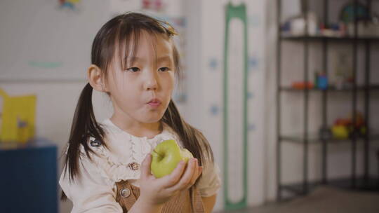 小女孩在教室里吃苹果