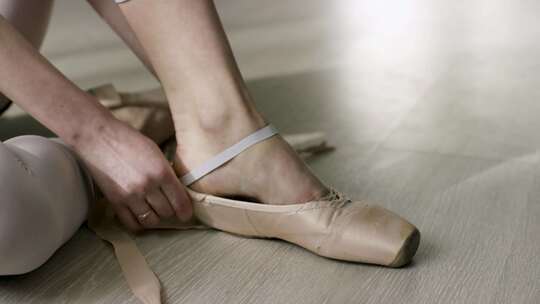芭蕾舞者系鞋带动作视频素材模板下载