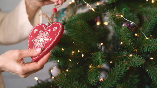在圣诞树上挂红心的特写镜头
