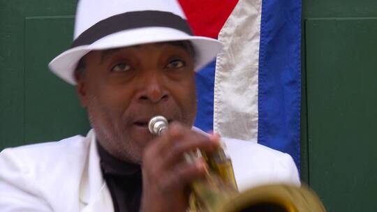 爵士音乐家在古巴哈瓦那的街道上吹小号视频素材模板下载