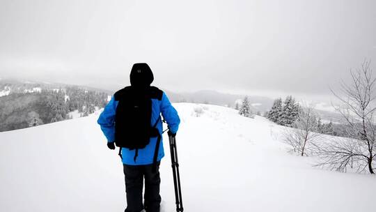 雪地里拿着相机和三脚架的摄影师