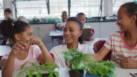 在自然研究课上，不同的学童和老师在教室里种植植物