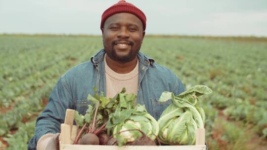 菜园里抱着一篮子蔬菜微笑的农夫