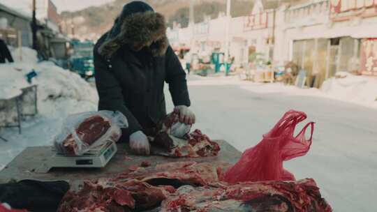 冬季东北小镇街道集市售卖新鲜牛肉画面