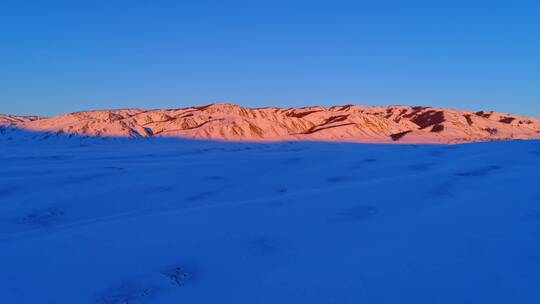 新疆阿勒泰雪山红色夕阳下的村落