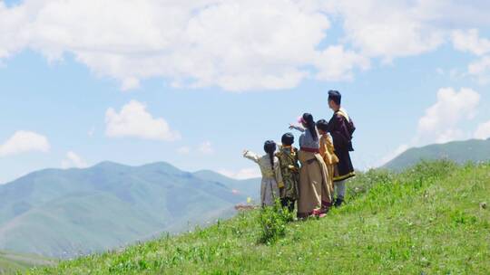 少数民族大人和小孩站在山顶眺望远方视频素材模板下载