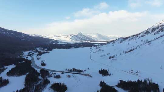 航拍新疆冬季喀纳斯湖雪景雪山森林冰河晨雾