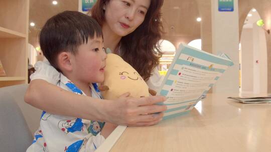 妈妈陪小孩看书，妈妈给孩子讲故事