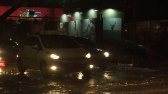 暴雨导致小街上的汽车通过洪水