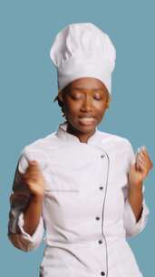 垂直视频兴奋微笑的女人厨师做舞步