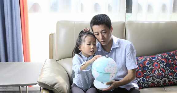 爸爸教女儿看地球仪学地理知识