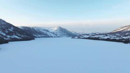 航拍新疆冬季喀纳斯湖雪景雪山森林冰河寒冷