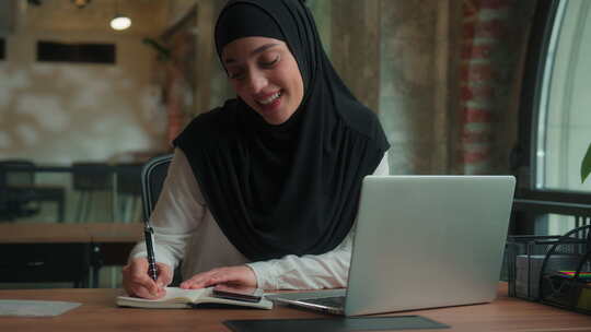 穆斯林伊斯兰妇女戴头巾说话视频通话会议笔