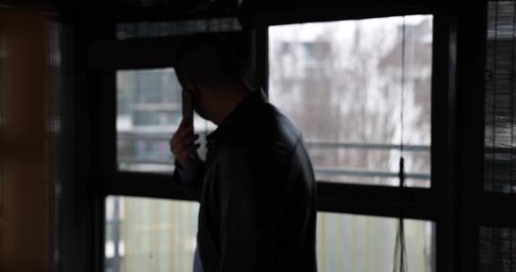 一个男人独自蹲坐阳台抽烟 电话压力大4k