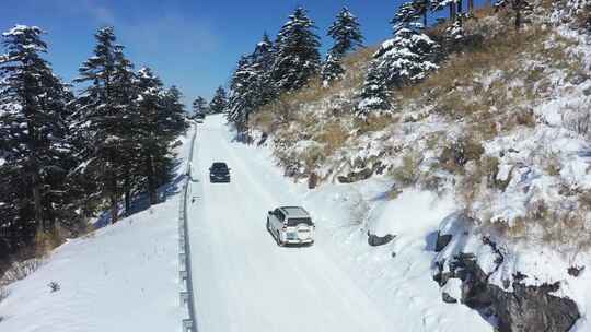 航拍冬天山路雪地上行驶的汽车