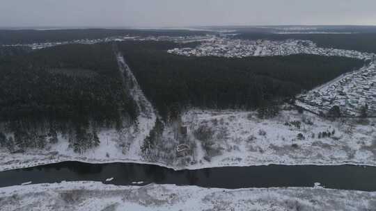 森林附近冬季河流的鸟瞰图。在遥远的村庄。主要多云04