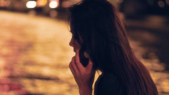女孩夜晚在江边打电话4k视频素材