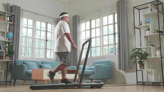 肥胖男子居家跑步机上锻炼减肥视频素材模板下载