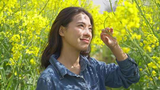 油菜花海里赏花的美女特写春天阳光温暖