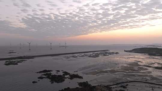 海边日出时的风力发电场全景