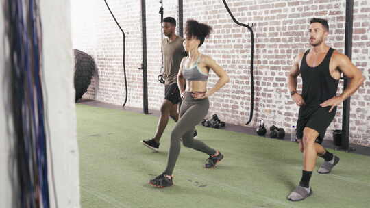 锻炼，能量和人们在健身房一起弓步，一起锻