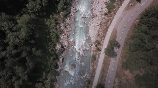 法国阿尔卑斯山威尼斯森林之间流淌的绿松石冰川河流的空中自上而下照片。